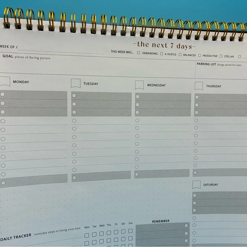 Zerone Productivity weekly planner featuring a gold spiral binding.